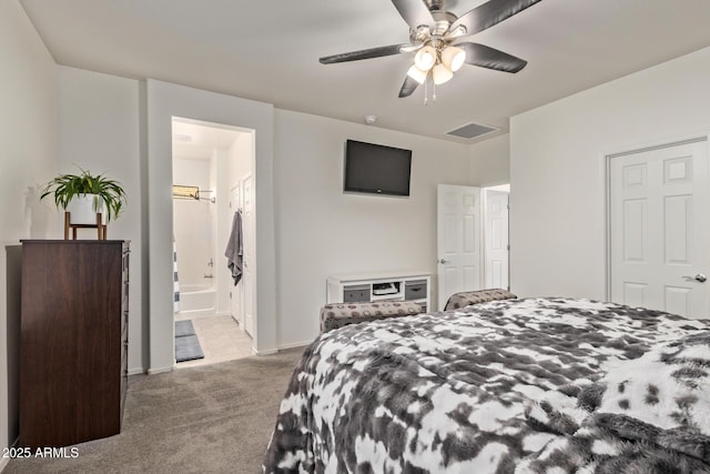 bedroom featuring ensuite bathroom, light carpet, and ceiling fan