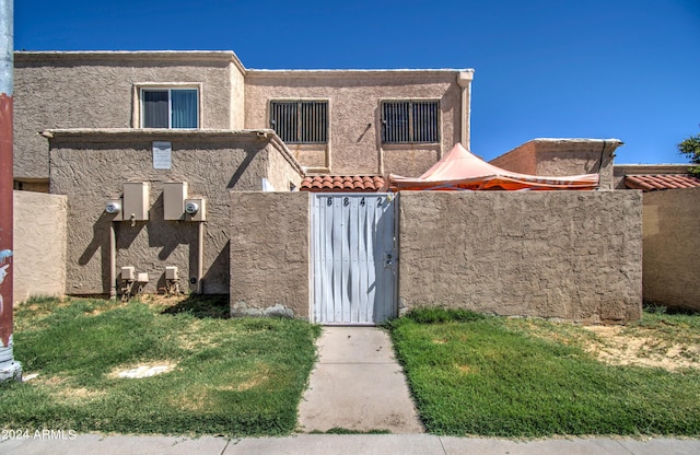 view of front of house featuring a fenced front yard, a gate, and stucco siding