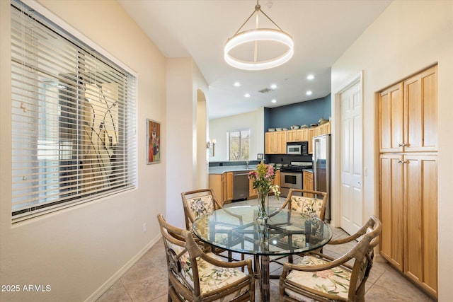 dining area featuring arched walkways, light tile patterned flooring, recessed lighting, visible vents, and baseboards