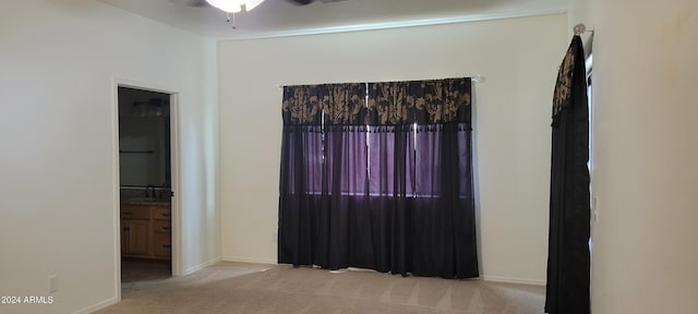 carpeted spare room featuring ceiling fan