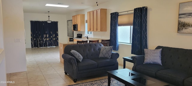 living room featuring sink and light tile patterned floors