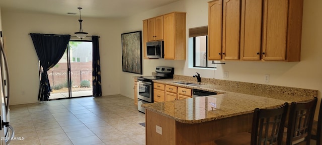 kitchen with pendant lighting, sink, appliances with stainless steel finishes, light stone counters, and kitchen peninsula