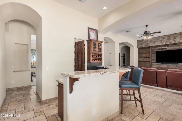21615 E Pegasus Pkwy, Queen Creek, AZ 85142 - kitchen with recessed lighting, stone tile floors, a kitchen breakfast bar, built in features, and ceiling fan