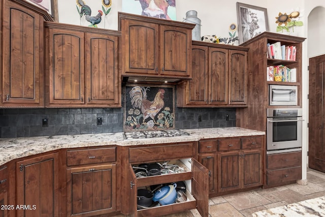 21615 E Pegasus Pkwy, Queen Creek, AZ 85142 - kitchen featuring light stone counters, open shelves, tasteful backsplash, stone tile flooring, and appliances with stainless steel finishes
