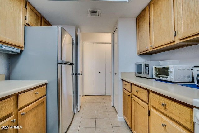 kitchen featuring stainless steel refrigerator and light tile patterned floors