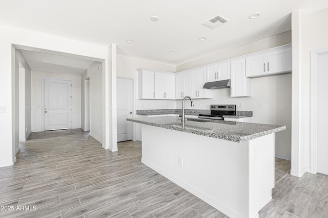 37478 W Hayes St, Tonopah, AZ 85354 - kitchen with stainless steel electric range, under cabinet range hood, white cabinets, light wood finished floors, and a kitchen island with sink
