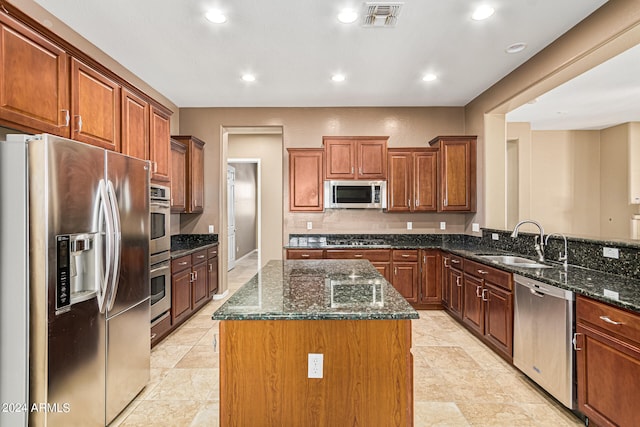 kitchen featuring a center island, stainless steel appliances, sink, kitchen peninsula, and dark stone counters