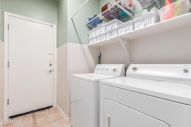 laundry area with light tile patterned floors and washer and clothes dryer