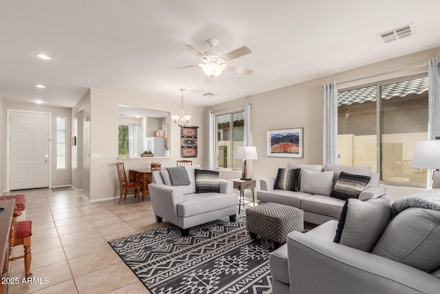 tiled living room with ceiling fan with notable chandelier