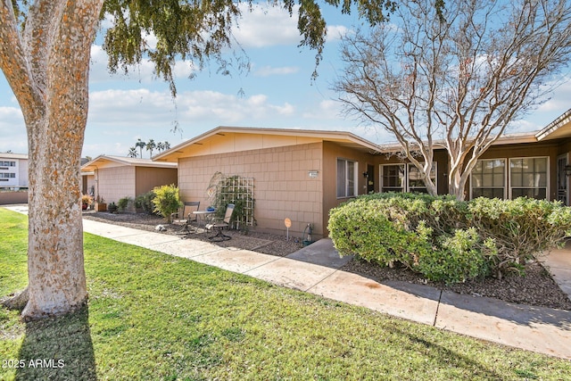 ranch-style house featuring a front lawn