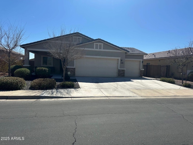 view of front of house with fence, driveway, an attached garage, stucco siding, and stone siding