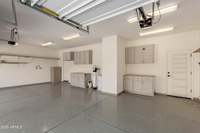 garage featuring a garage door opener and baseboards