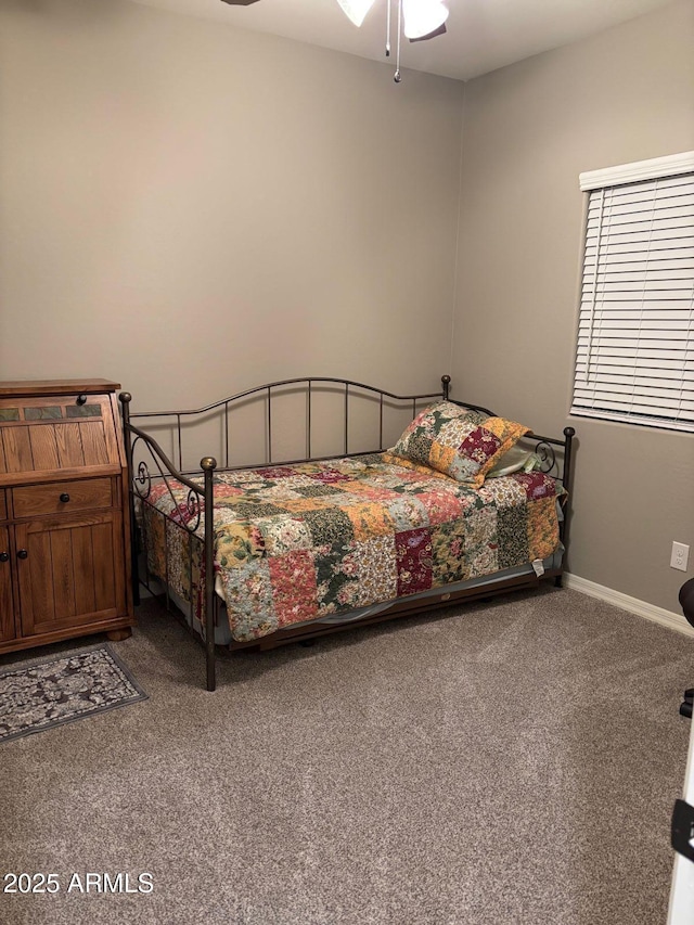 carpeted bedroom with a ceiling fan and baseboards