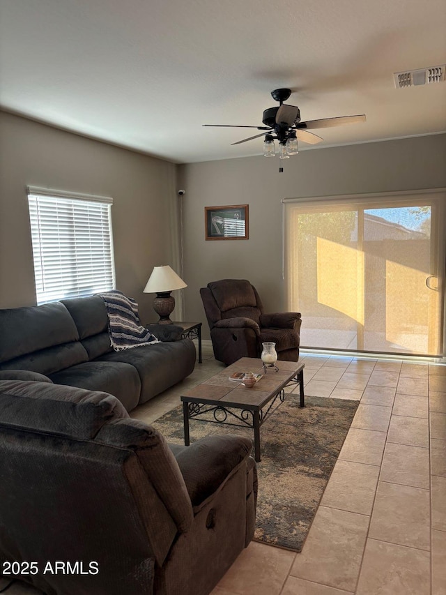 tiled living area with visible vents and a ceiling fan