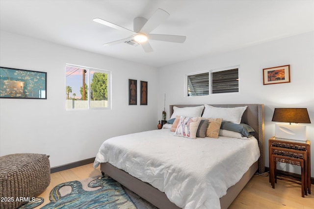 bedroom featuring light wood finished floors, baseboards, and a ceiling fan