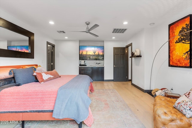 bedroom with baseboards, light wood-style floors, visible vents, and recessed lighting