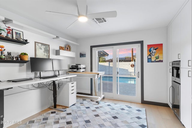 home office with ceiling fan, light wood finished floors, and visible vents