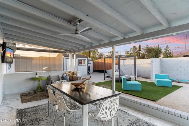 view of patio with a ceiling fan, a fenced backyard, an outbuilding, a storage unit, and outdoor dining area