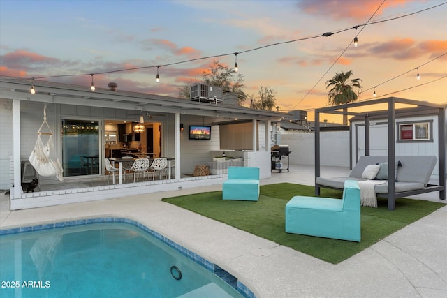 rear view of house with a patio, an outdoor living space, a fenced in pool, and central air condition unit