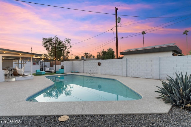 pool at dusk featuring a patio area, a fenced backyard, and a fenced in pool