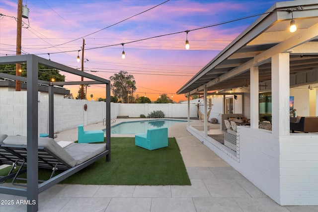 pool at dusk with a patio area, a fenced backyard, and a fenced in pool