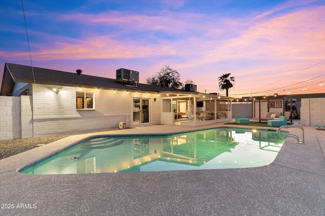 pool at dusk featuring central air condition unit, a fenced in pool, and a patio