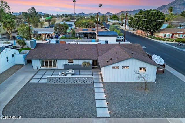 aerial view at dusk featuring a residential view and a mountain view