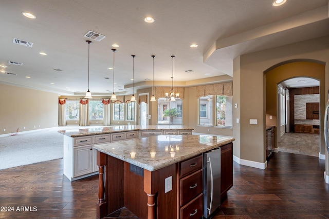 kitchen featuring a large island, dark hardwood / wood-style floors, light stone countertops, and plenty of natural light