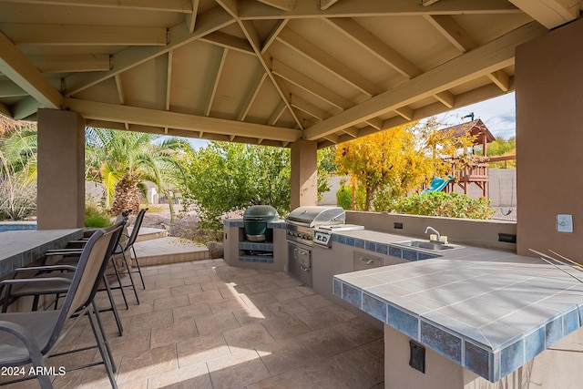 view of patio / terrace featuring a gazebo, grilling area, exterior kitchen, and a wet bar