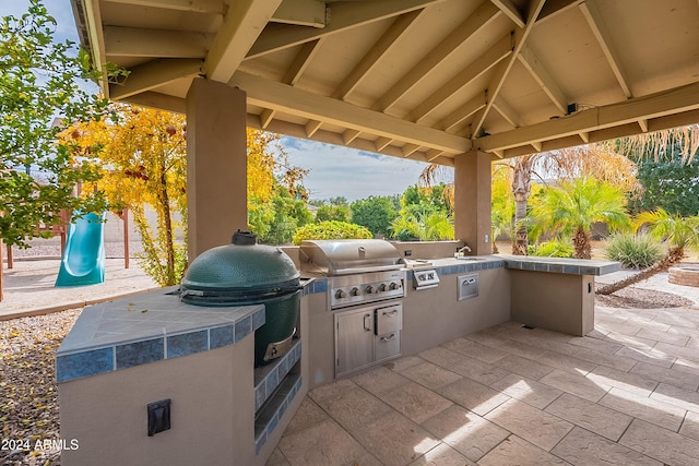 view of patio with a playground, area for grilling, sink, and a gazebo