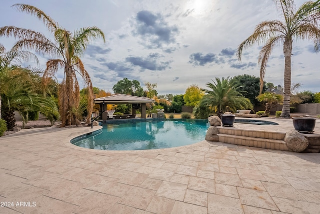 view of swimming pool featuring a gazebo, an in ground hot tub, and a patio