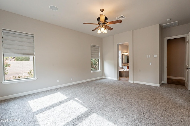 unfurnished bedroom with ensuite bathroom, ceiling fan, and light carpet