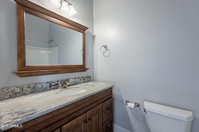 bathroom with vanity, toilet, and walk in shower