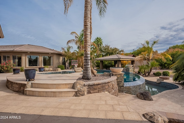 view of pool with a gazebo, an in ground hot tub, and grilling area