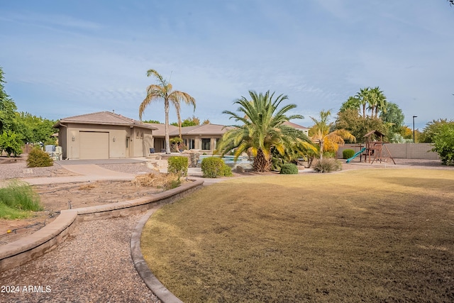 view of front of property with a playground and a garage