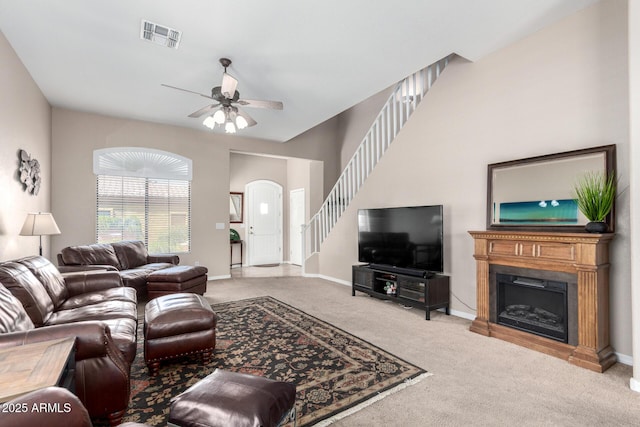3041 E Fremont Rd, Phoenix, AZ 85042 - carpeted living area featuring ceiling fan, stairs, a fireplace, and arched walkways
