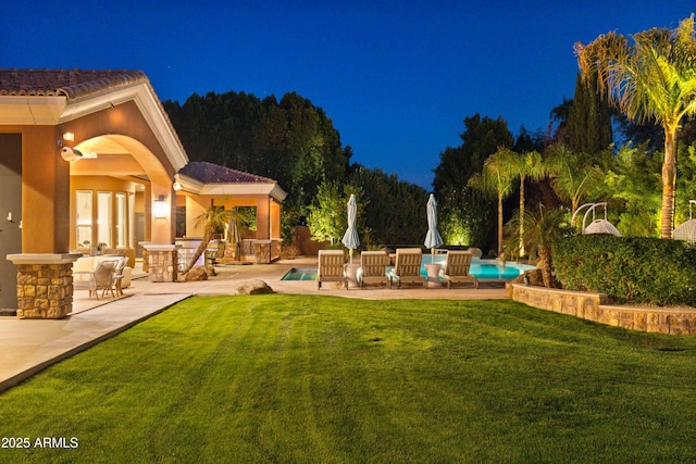 yard at twilight featuring a patio and an outdoor pool