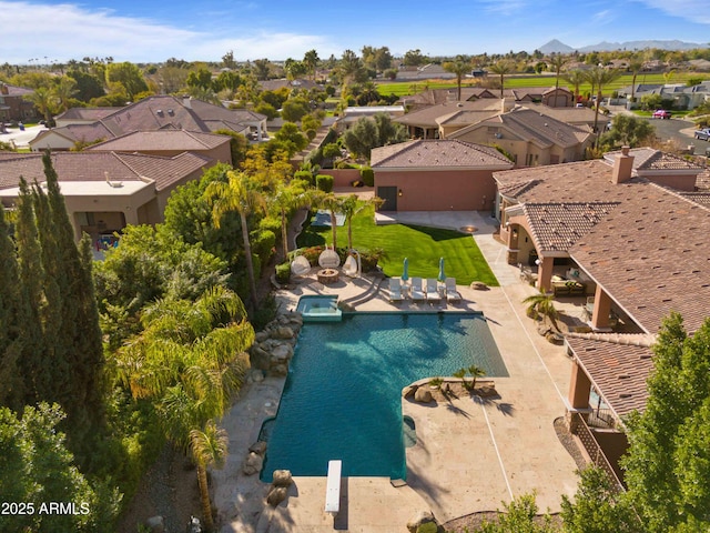 view of swimming pool with a patio area, a pool with connected hot tub, and a residential view