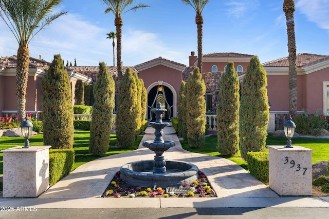 exterior space featuring a front yard, a tile roof, and stucco siding