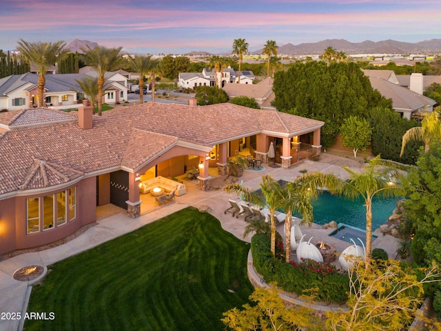 exterior space featuring a lawn, a patio, a mountain view, an outdoor living space, and stucco siding