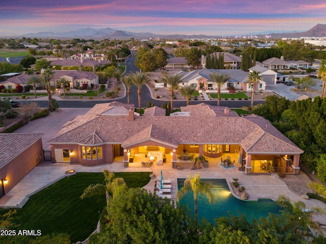 aerial view at dusk featuring a mountain view and a residential view