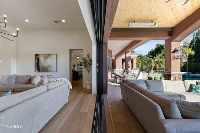 living room with a chandelier, recessed lighting, visible vents, and wood finished floors