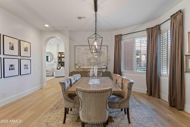 dining space featuring visible vents, arched walkways, baseboards, light wood-style flooring, and recessed lighting