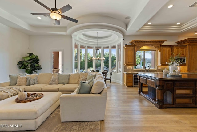 living room with recessed lighting, beverage cooler, visible vents, light wood-style floors, and a tray ceiling