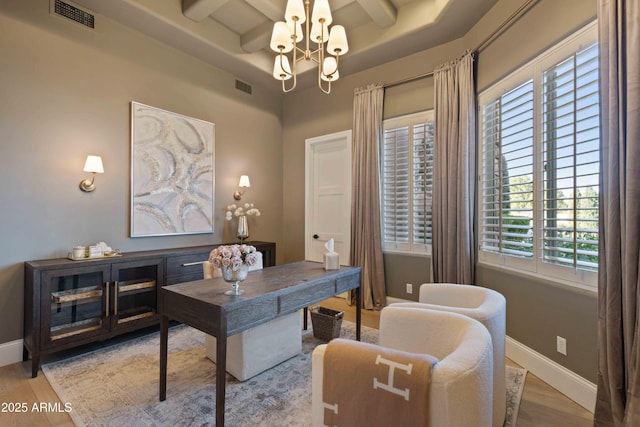 home office featuring a chandelier, visible vents, baseboards, and wood finished floors