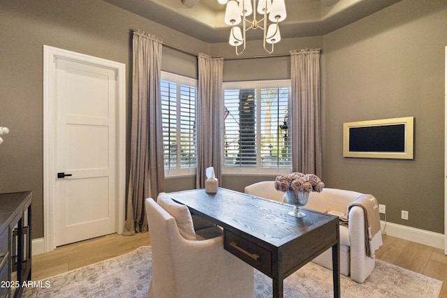 home office with light wood-type flooring, baseboards, and a chandelier