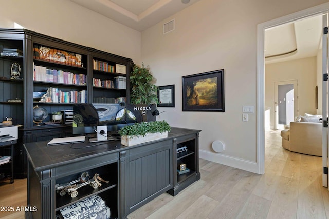 home office featuring baseboards, visible vents, and light wood finished floors