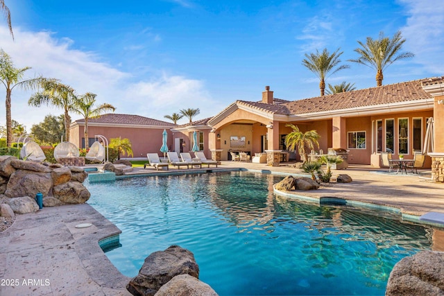 pool with an in ground hot tub and a patio