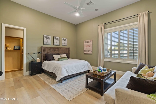 bedroom with light wood-type flooring, baseboards, visible vents, and a ceiling fan