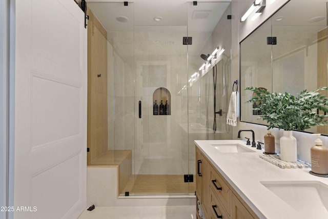 full bathroom featuring a sink, a shower stall, and double vanity